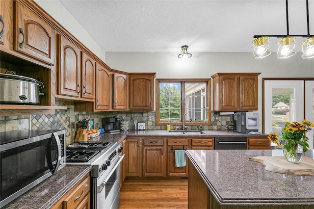 715 W Coolidge Ave, Charleston, IL 61920 - kitchen featuring appliances with stainless steel finishes, plenty of natural light, brown cabinets, light wood finished floors, and a textured ceiling