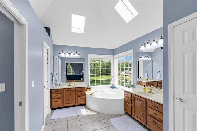 715 W Coolidge Ave, Charleston, IL 61920 - bathroom with a skylight, two vanities, a garden tub, vaulted ceiling, and tile patterned floors
