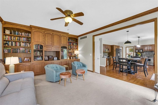 715 W Coolidge Ave, Charleston, IL 61920 - living area with light colored carpet, a ceiling fan, and crown molding