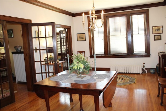 300 W N 1st St, Shelbyville, IL 62565 - dining space with radiator, a chandelier, wood finished floors, and ornamental molding