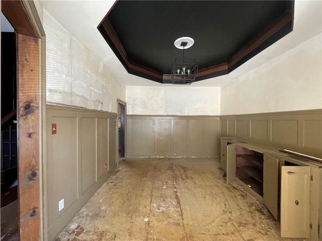 interior space with a raised ceiling and crown molding