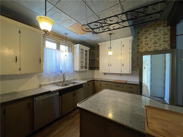 kitchen featuring dark wood-type flooring, tasteful backsplash, stainless steel dishwasher, decorative light fixtures, and white cabinets