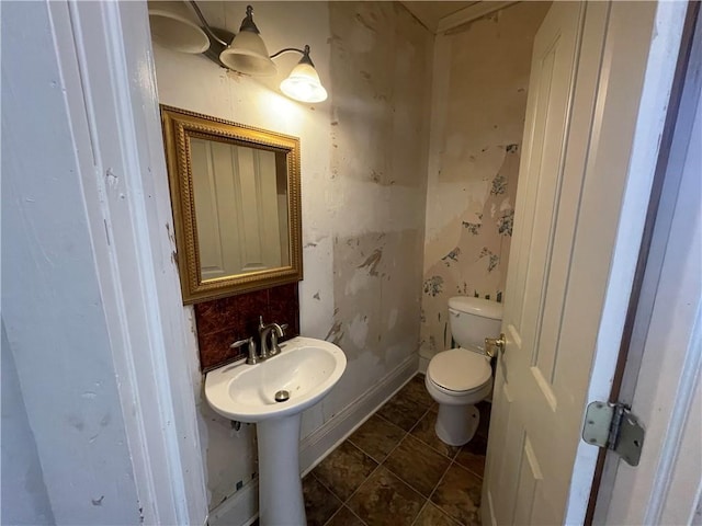 bathroom with decorative backsplash and toilet