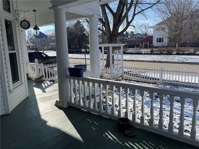 snow covered deck featuring a porch