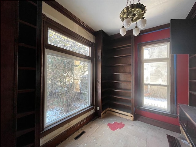 interior space with a chandelier and crown molding