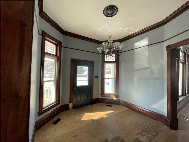 entrance foyer featuring ornamental molding and a chandelier