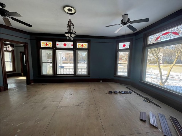 empty room with ceiling fan, ornamental molding, and a wealth of natural light