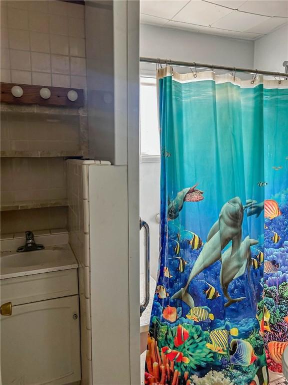 bathroom with a shower with shower curtain and vanity