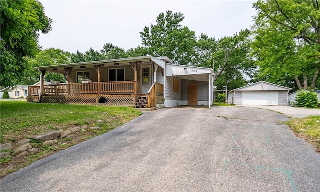 559 N Excelsior Rd, Decatur, IL 62521 - view of front facade with covered porch, a carport, an outdoor structure, a detached garage, and a front yard