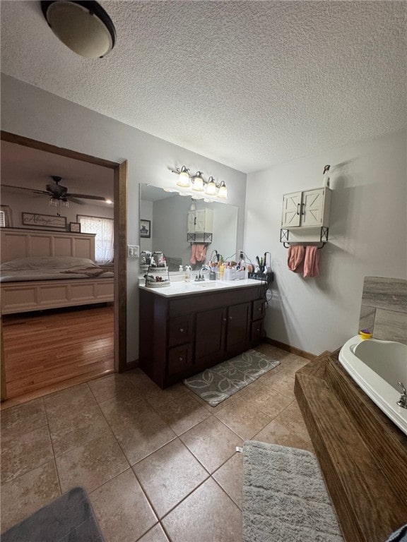 6414 300th Rd, Martinsville, IL 62442 - ensuite bathroom with a garden tub, vanity, tile patterned flooring, a textured ceiling, and a ceiling fan