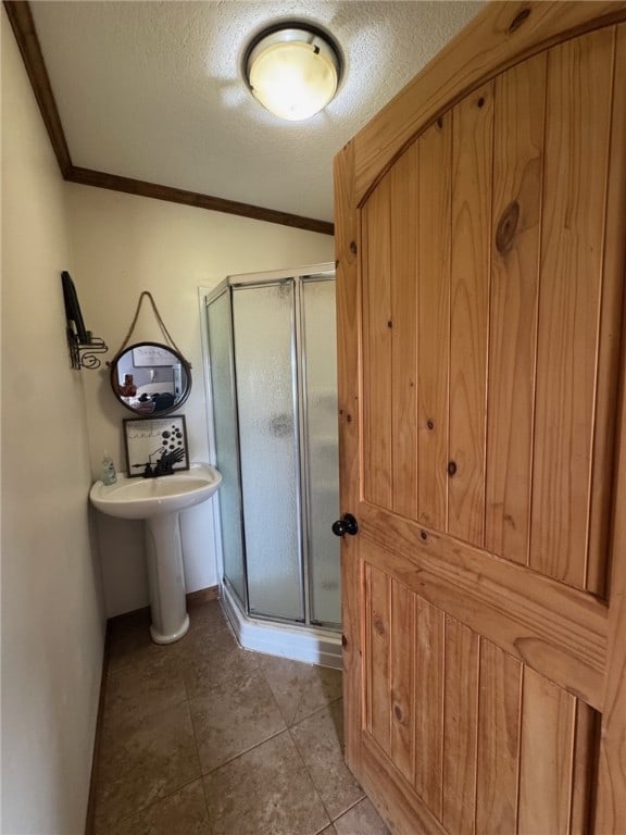 6414 300th Rd, Martinsville, IL 62442 - bathroom featuring a stall shower, crown molding, a textured ceiling, and tile patterned flooring