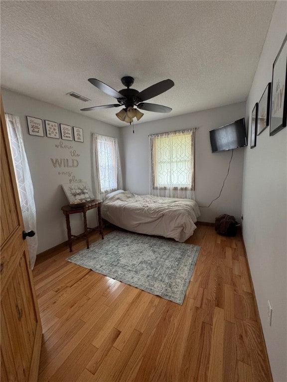 6414 300th Rd, Martinsville, IL 62442 - bedroom featuring a textured ceiling, light wood-style floors, and ceiling fan