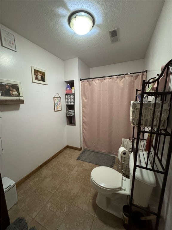 6414 300th Rd, Martinsville, IL 62442 - bathroom featuring toilet, a textured ceiling, baseboards, and curtained shower