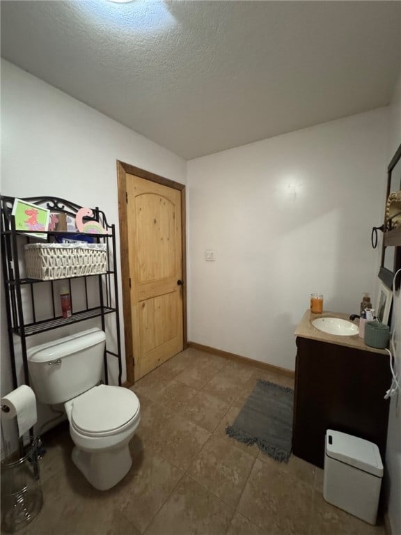 6414 300th Rd, Martinsville, IL 62442 - bathroom featuring toilet, vanity, a textured ceiling, and baseboards