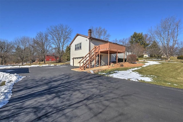 exterior space with a wooden deck, a garage, and a yard