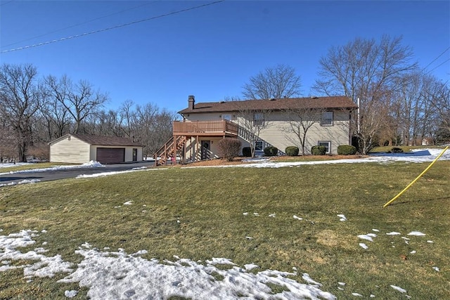 view of front of property with a wooden deck, a garage, an outdoor structure, and a yard