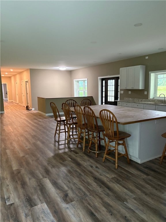 dining space with dark wood-type flooring and baseboards