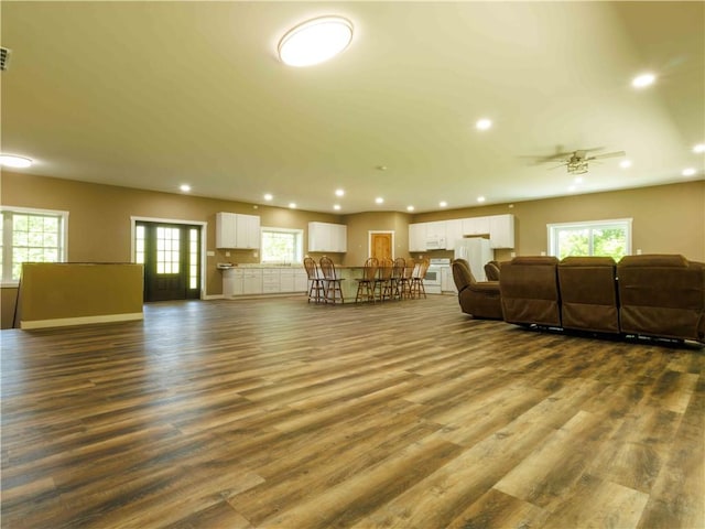 living area with recessed lighting, a ceiling fan, plenty of natural light, and dark wood finished floors