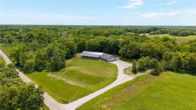 aerial view of property and surrounding area with a heavily wooded area