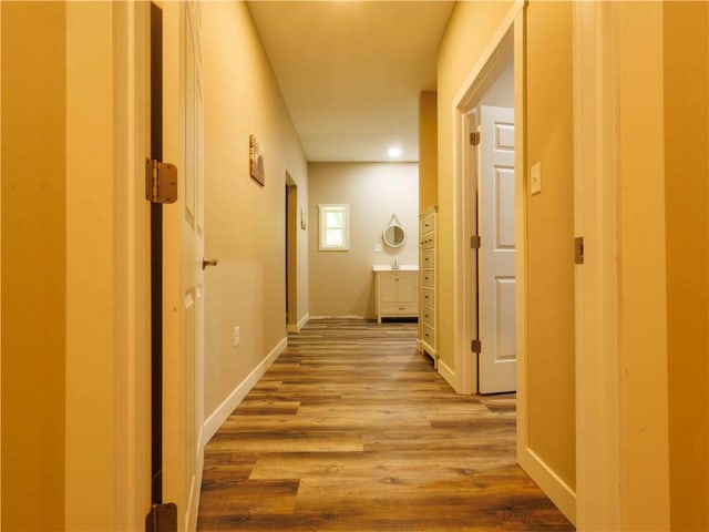hall featuring wood finished floors and baseboards