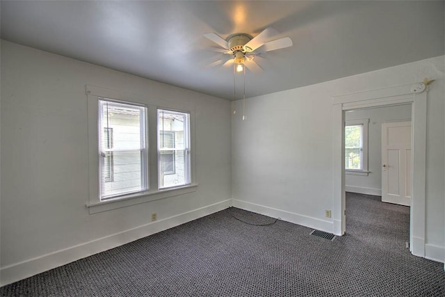 1263 E Dickinson Ave, Decatur, IL 62521 - unfurnished room with dark colored carpet, plenty of natural light, ceiling fan, and a smoke detector