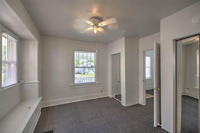 1263 E Dickinson Ave, Decatur, IL 62521 - unfurnished bedroom featuring dark colored carpet and a ceiling fan