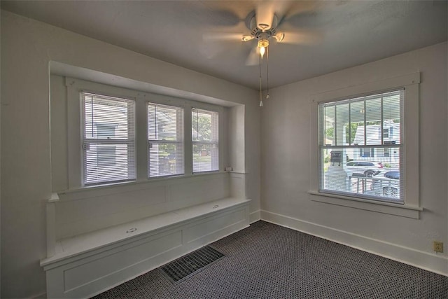 1263 E Dickinson Ave, Decatur, IL 62521 - unfurnished dining area with dark colored carpet, plenty of natural light, and a ceiling fan