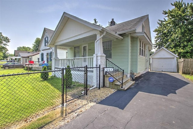 1263 E Dickinson Ave, Decatur, IL 62521 - view of front of home with covered porch, a fenced front yard, asphalt driveway, and a detached garage