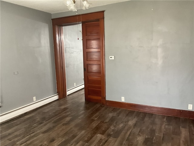 unfurnished room with a baseboard radiator and dark wood-type flooring