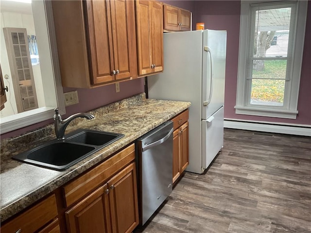 kitchen with sink, baseboard heating, stainless steel appliances, and dark wood-type flooring