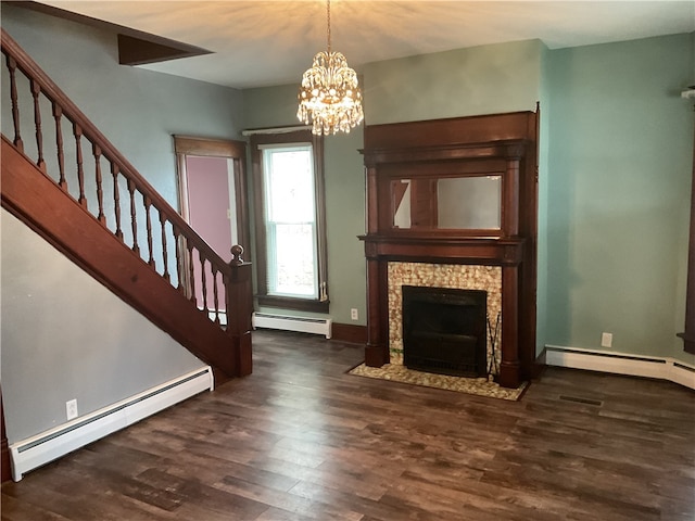 unfurnished living room featuring dark hardwood / wood-style flooring, a baseboard heating unit, and an inviting chandelier