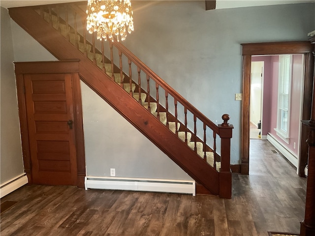 stairs with wood-type flooring, baseboard heating, and an inviting chandelier