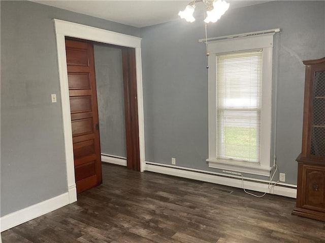 spare room with dark hardwood / wood-style flooring and baseboard heating