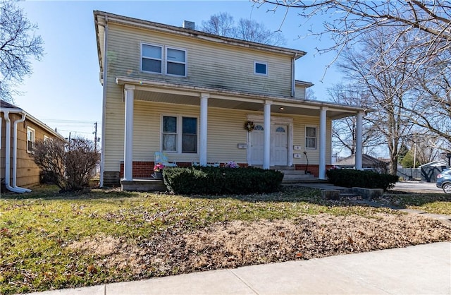 view of front of home with a front yard and covered porch