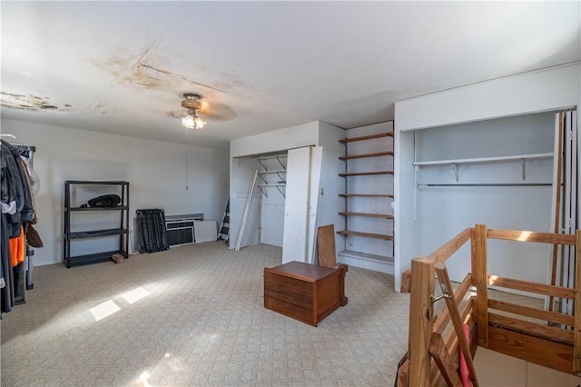 interior space with a ceiling fan and multiple closets