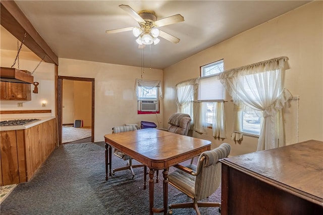 dining room featuring cooling unit, dark colored carpet, and ceiling fan