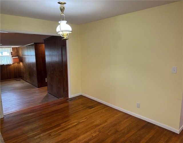 824 Kenton Dr, Charleston, IL 61920 - spare room with dark wood finished floors and wood walls