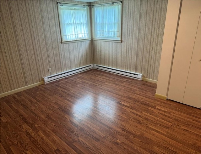 824 Kenton Dr, Charleston, IL 61920 - unfurnished bedroom featuring wood finished floors, baseboard heating, and wallpapered walls
