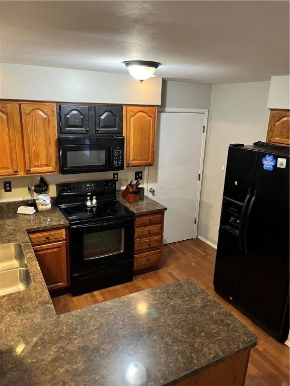 1021 W Hayes Ave, Charleston, IL 61920 - kitchen featuring black appliances, brown cabinets, wood finished floors, and dark stone counters