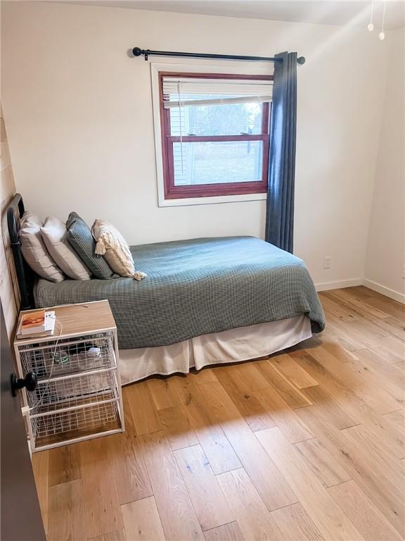 bedroom featuring baseboards and wood finished floors