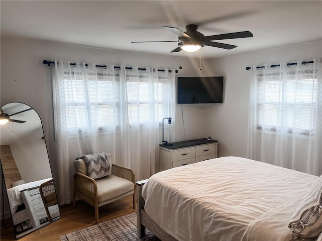 bedroom featuring light wood finished floors, multiple windows, and a ceiling fan