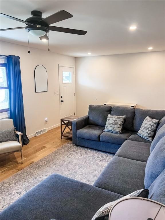 living area featuring baseboards, visible vents, wood finished floors, and recessed lighting