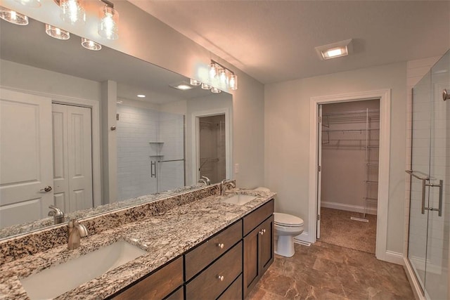 bathroom featuring toilet, vanity, and walk in shower