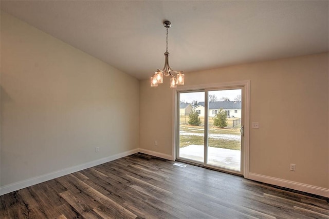 unfurnished room featuring vaulted ceiling, dark wood-type flooring, and a notable chandelier