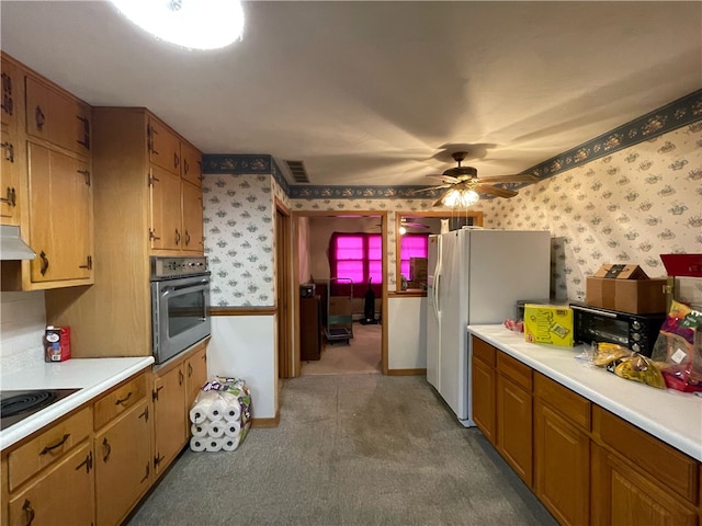 kitchen featuring carpet flooring, black electric stovetop, stainless steel oven, ceiling fan, and white refrigerator