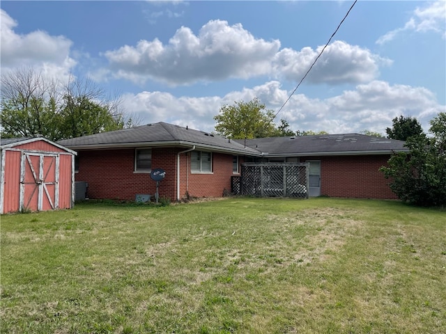 rear view of house featuring a storage shed and a lawn