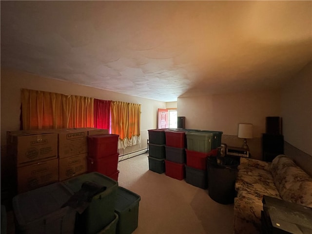 interior space with light carpet and a baseboard heating unit