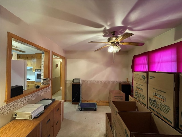 interior space with white refrigerator, light colored carpet, oven, and ceiling fan