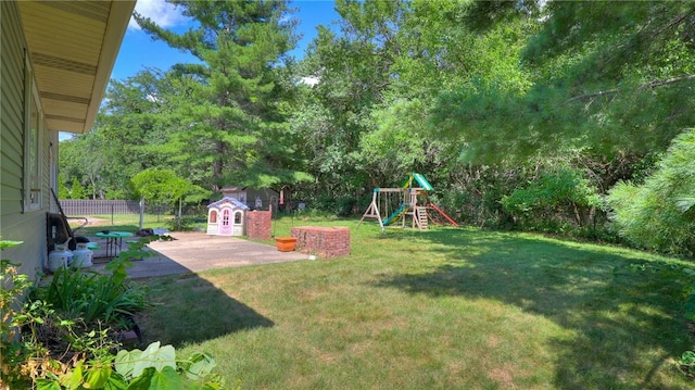 162 S Hillcrest Blvd, Decatur, IL 62522 - fenced backyard with a playground, a patio, and an outbuilding