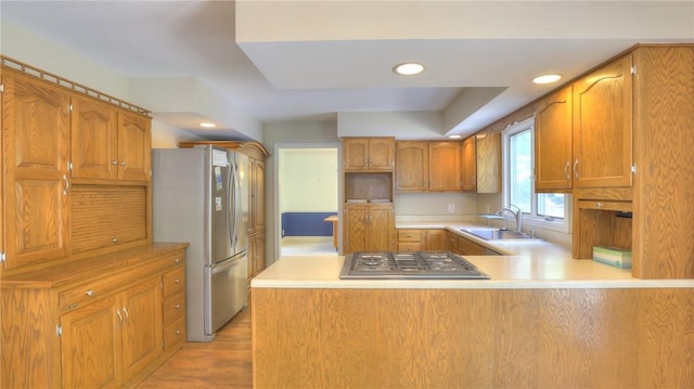 162 S Hillcrest Blvd, Decatur, IL 62522 - kitchen featuring stainless steel appliances, a peninsula, light countertops, brown cabinetry, and light wood-style flooring